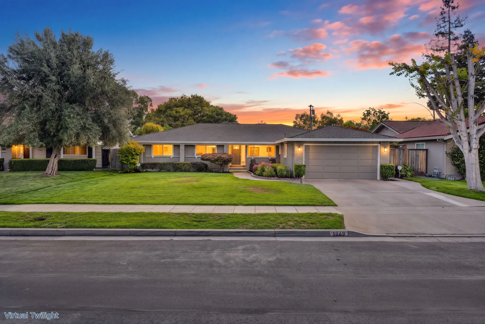 Single-story ranch home with lit windows behind a wide lawn at twilight, San Jose