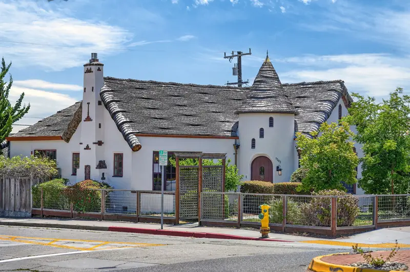 Storybook cottage with a turret and a rolled shingle roof, Santa Cruz