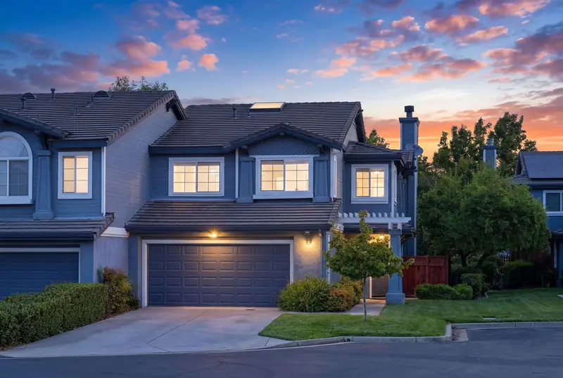 Two-story blue townhome with a two-car garage at twilight, Livermore