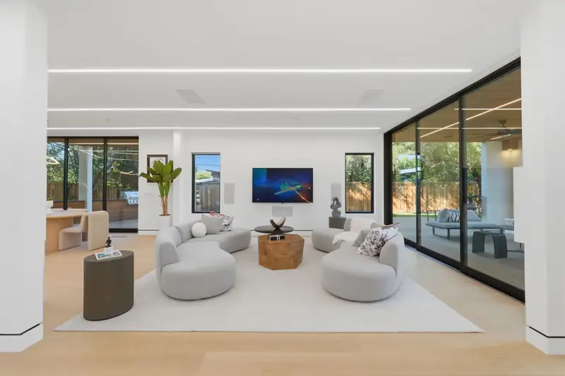 Bright open living room with curved sofas and a wall of glass sliders, Mountain View
