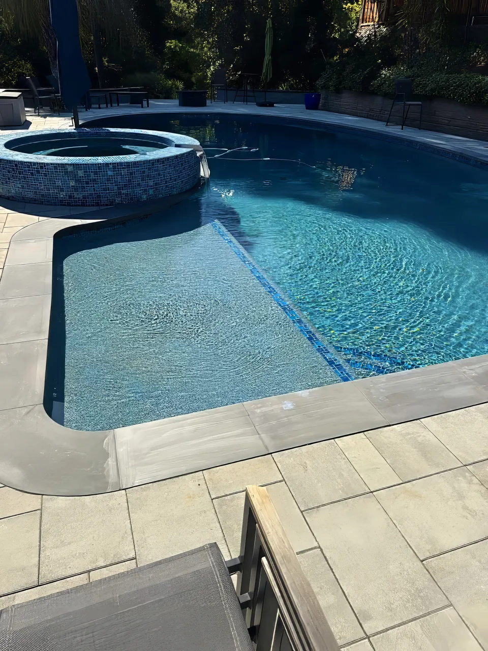 Tanning ledge: glass tile step and ledge edge with a raised spa behind