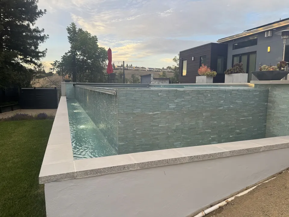Glass-tile wall and catch basin of the raised vanishing-edge pool