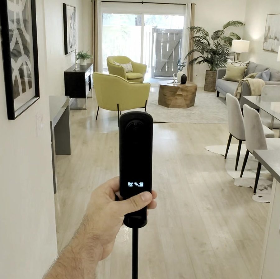 The Theta Z1 held out on its stick in a staged living room